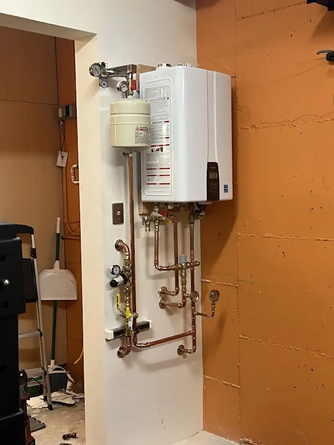 Plumbing technician inspecting water heater connections in Lacey